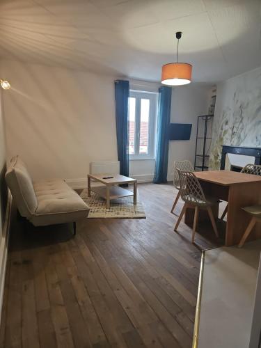a living room with a table and a dining room at Appartement coquet à la Machine in La Machine