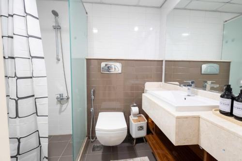 a bathroom with a toilet and a sink at Azure Sands 2BR Escape with Priavte Beach and Pool in Al Marjan Island in Ras al Khaimah