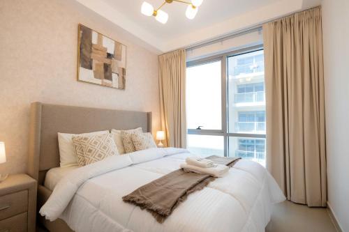 a bedroom with a large bed with a large window at Azure Sands 2BR Escape with Priavte Beach and Pool in Al Marjan Island in Ras al Khaimah