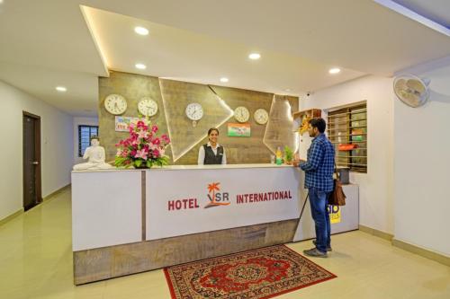 Ein Mann steht an der Hotelrezeption. in der Unterkunft FabHotel VSR International in Shamshabad