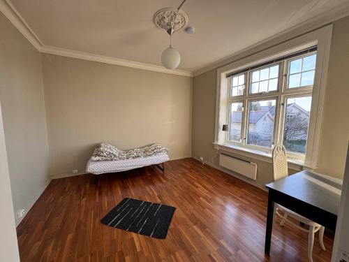 an empty living room with a piano and wooden floors at Brekkehagen in Skien