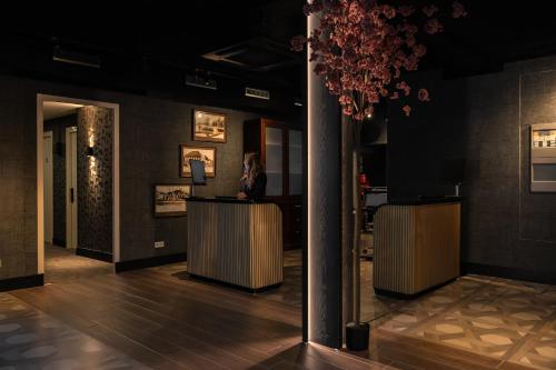 a woman sitting at a counter in a lobby at Hotel Twenty-Three Amsterdam Airport in Hoofddorp