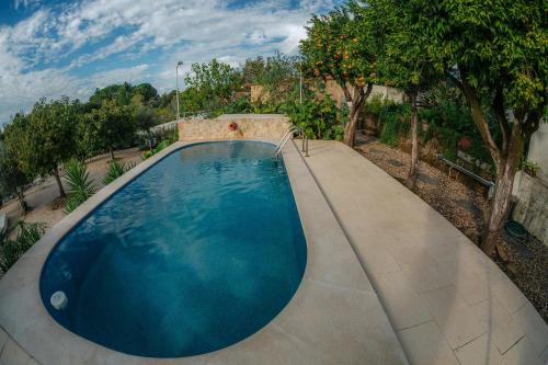 a swimming pool with a concrete walkway around it at Quinta Castilho in Alviobeira