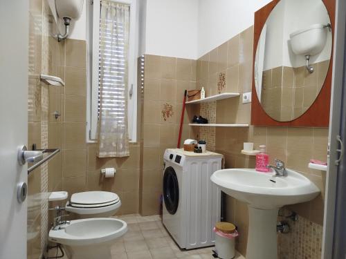 une salle de bain avec un lavabo, des toilettes et un miroir dans l'établissement App - Il Fenicottero con parcheggio gratuito ad Orbetello, à Orbetello