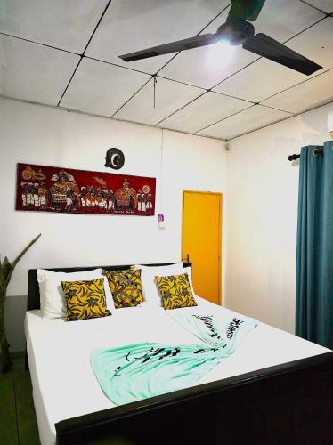 a bedroom with a white bed with a blue and yellow blanket at Sea Bay in Kamburugamuwa