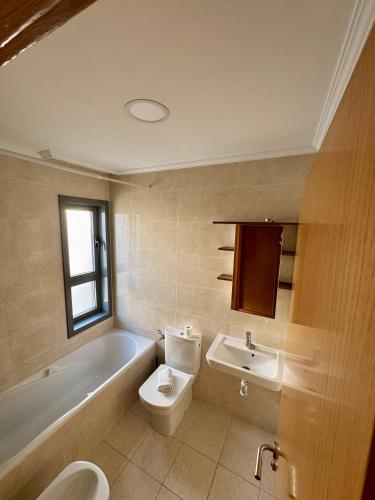 a bathroom with a toilet and a tub and a sink at Primera Linea de Playa in Bueu