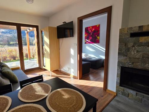 ein Wohnzimmer mit Tisch und Kamin in der Unterkunft Domek GORCZAŃSKA KOLIBA w Gorcach in Kamienica