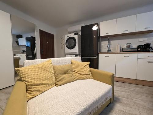 uma sala de estar com um sofá e uma cozinha em Cozy Condo in Tresnjevka em Zagreb