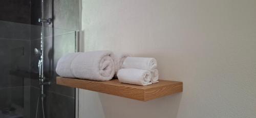 Una pila de toallas en un estante de madera en un baño. en Deluxe Studio, en Oranjestad