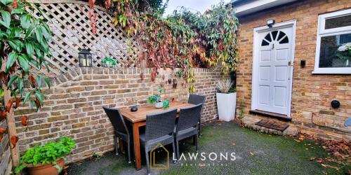 a patio with a table and chairs next to a brick wall at Windsor 1BR Gem with Free Parking in Windsor