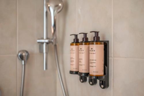 Un grupo de cuatro botellas de jabón colgadas en una pared en Serwir Hotel, en Sint-Niklaas