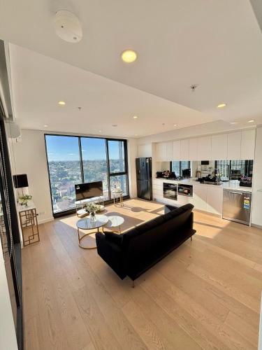 a large living room with a couch and a table at The Luxury Penthouse at Spring Square in Bankstown