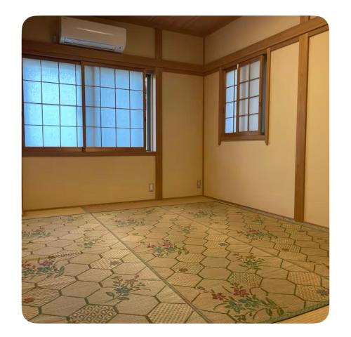 une pièce vide avec des fenêtres et un sol carrelé dans l'établissement ビーチ徒歩１分のプライベート空間、民宿やまぐち, à Susami