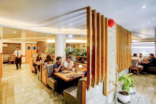 a group of people sitting at a restaurant at FabHotel Ratna Regency in Chinchiwad
