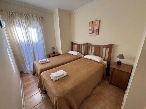 Una habitación de hotel con dos camas con toallas. en Jacaranda A, en Pedreguer