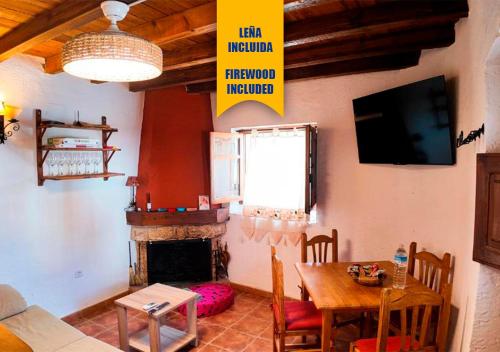 ein Wohnzimmer mit Tisch und Kamin in der Unterkunft Ruralux Orcera Linarejos I in Orcera