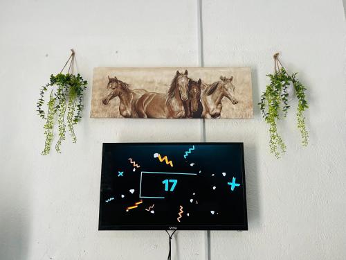 a clock hanging on a wall with horses on it at Hlatsi Bushview Apartments & Safaris in Hazyview