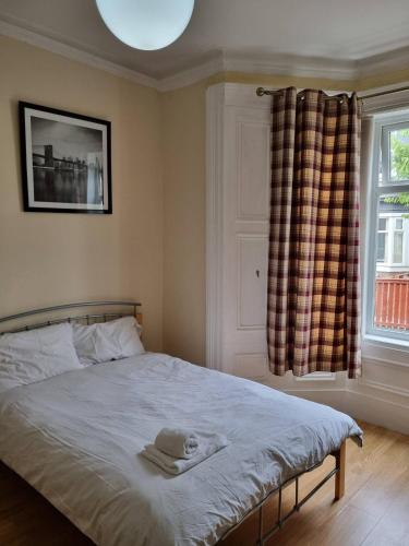 - une chambre avec un lit avec un chapeau et une fenêtre dans l'établissement Private Room, Tyne Wear, à Sunderland