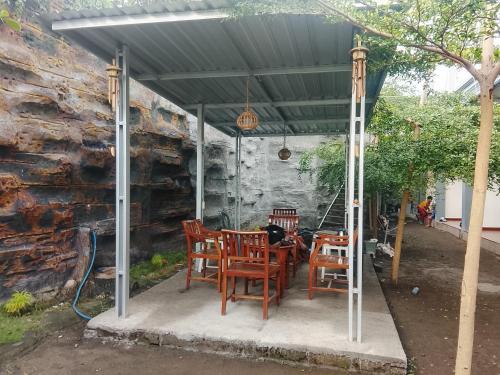 eine Terrasse mit einem Tisch und Stühlen unter einem Dach in der Unterkunft Pandava House Lombok in Lombok International Airport