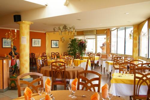 パミエにあるHôtel Le Roi Gourmandの黄色の壁のテーブルと椅子が備わるレストラン