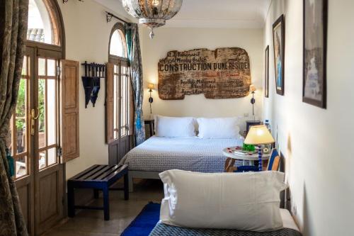 a guest room with a bed and a table at Riad Le Coq Berbère in Marrakesh