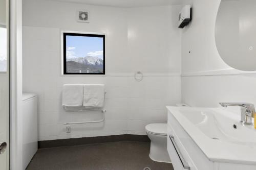 ein Badezimmer mit Waschbecken und Toilette und einem Fenster in der Unterkunft Central 2 bed Apt - views pool walk to town in Queenstown