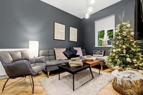 a living room with a christmas tree and a couch at The Gate House-Wyndale Living- West Malvern in Great Malvern