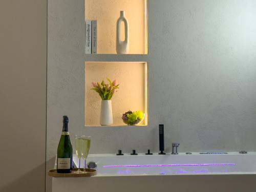 La salle de bains est pourvue d'un lavabo et d'une bouteille de vin. dans l'établissement URBAN APARTMENTS GLOBAL, Jacuzzi, 8th floor No 03, Free Garage, Self Check-in, No deposit, à Katowice