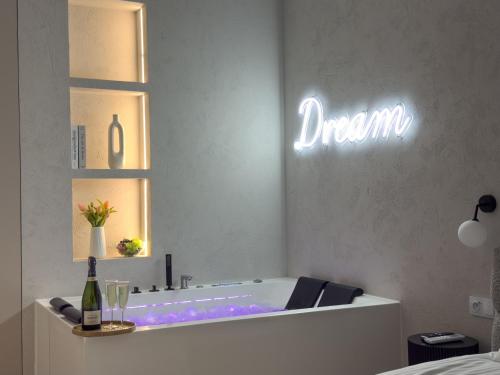 une salle de bain avec une baignoire et un panneau indiquant « rêve » dans l'établissement URBAN APARTMENTS GLOBAL, Jacuzzi, 8th floor No 03, Free Garage, Self Check-in, No deposit, à Katowice