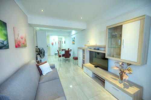 a living room with a couch and a television at 54, Emerald in San Pietru