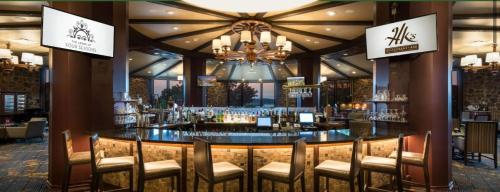 eine Bar in einem Restaurant mit Stühlen und einem Kronleuchter in der Unterkunft Fairway To Heaven At Four Season 2bed2bath Condo in Lake Ozark