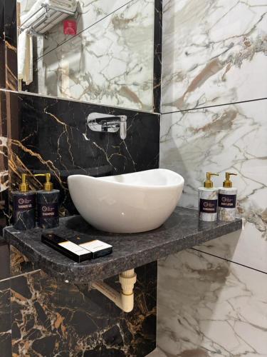 a bathroom with a white sink on a marble counter at The Silk Route Resort in Chanderi