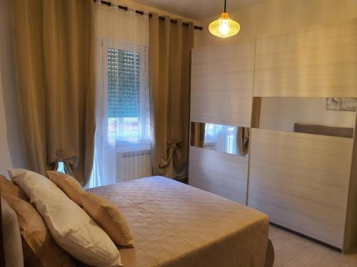 een slaapkamer met een bed en een groot raam bij Infinity Karla House 2 in Chioggia