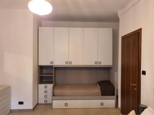 een kleine slaapkamer met een bed en witte kasten bij Infinity Karla House 2 in Chioggia