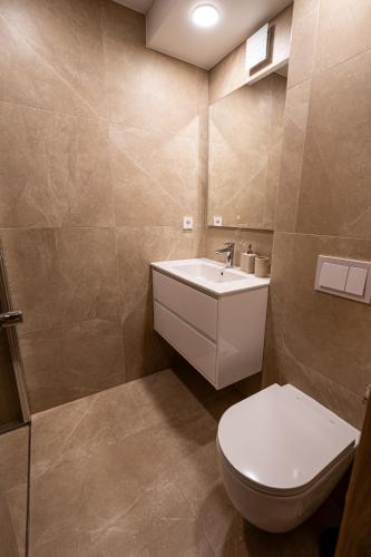 a bathroom with a toilet and a sink at Vytauto 12 - jaukūs apartamentai centre - Self Check-in in Marijampolė