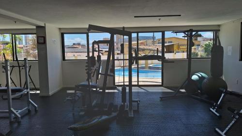 a gym with several tread machines and a swimming pool at Polyglot Family in Natal