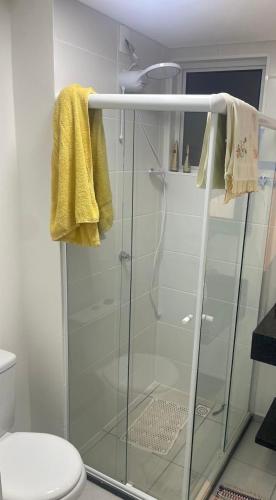 a bathroom with a glass shower with a toilet at Apartamento Itapoá in Itapoa