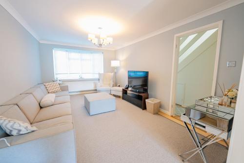 a living room with a couch and a television at 3 BR House With Free Parking, Garden & Fast Wifi in Cardiff