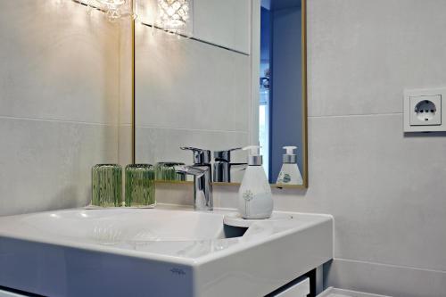 a bathroom with a white sink and a mirror at Ferienwohnung Sonnengarten in Meschede