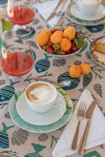 una mesa con una taza de café y un bol de fruta en MandorleOlio, en Polignano a Mare