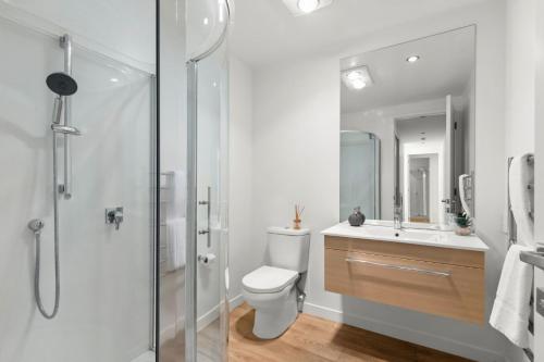 a bathroom with a shower and a toilet and a sink at Goldrush Way 4BR 3BA Lake & Mountain Views in Frankton Wharf