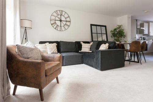 a living room with a couch and a chair at Runcorn Spacious Modern 3 bedroom House, 4 beds, On site Parking, Long stay deals in Runcorn