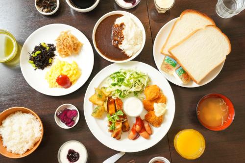 una mesa cubierta con platos de comida y pan en APA Hotel Shin Osaka Ekiminami, en Osaka