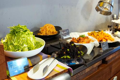 Un buffet con tazones de comida en una mesa. en APA Hotel Shin Osaka Ekiminami, en Osaka