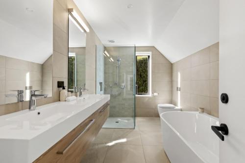 a bathroom with two sinks and a tub and a shower at Perfect on the Peninsula with Lake View and Hot Tub in Frankton Wharf