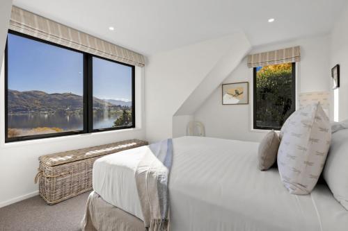a bedroom with a bed and a large window at Perfect on the Peninsula with Lake View and Hot Tub in Frankton Wharf