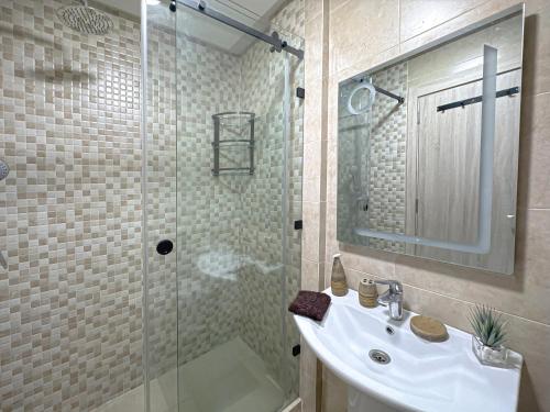 a bathroom with a sink and a glass shower at charming and cozy studio with swimming pool in Marrakesh
