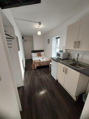 a small kitchen with a bed in a room at TLK Apartments & Hotel - Beckenham in Beckenham