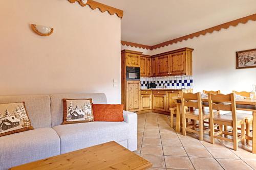 un salon avec un canapé et une cuisine dans l'établissement Borselier vue Montagne, Spa & Terrasse, à Champagny-en-Vanoise