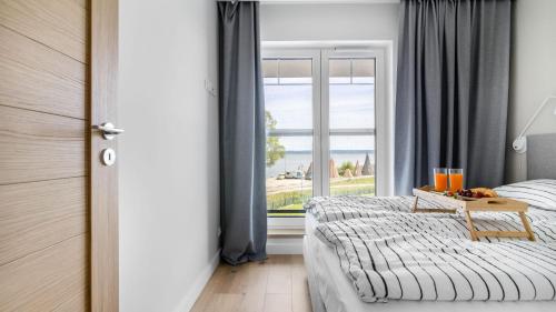 Ένα ή περισσότερα κρεβάτια σε δωμάτιο στο Port Krynica 16 - apartament premium w centrum Krynicy Morskiej z bezpośrednim widokiem na port i Zalew Wiślany